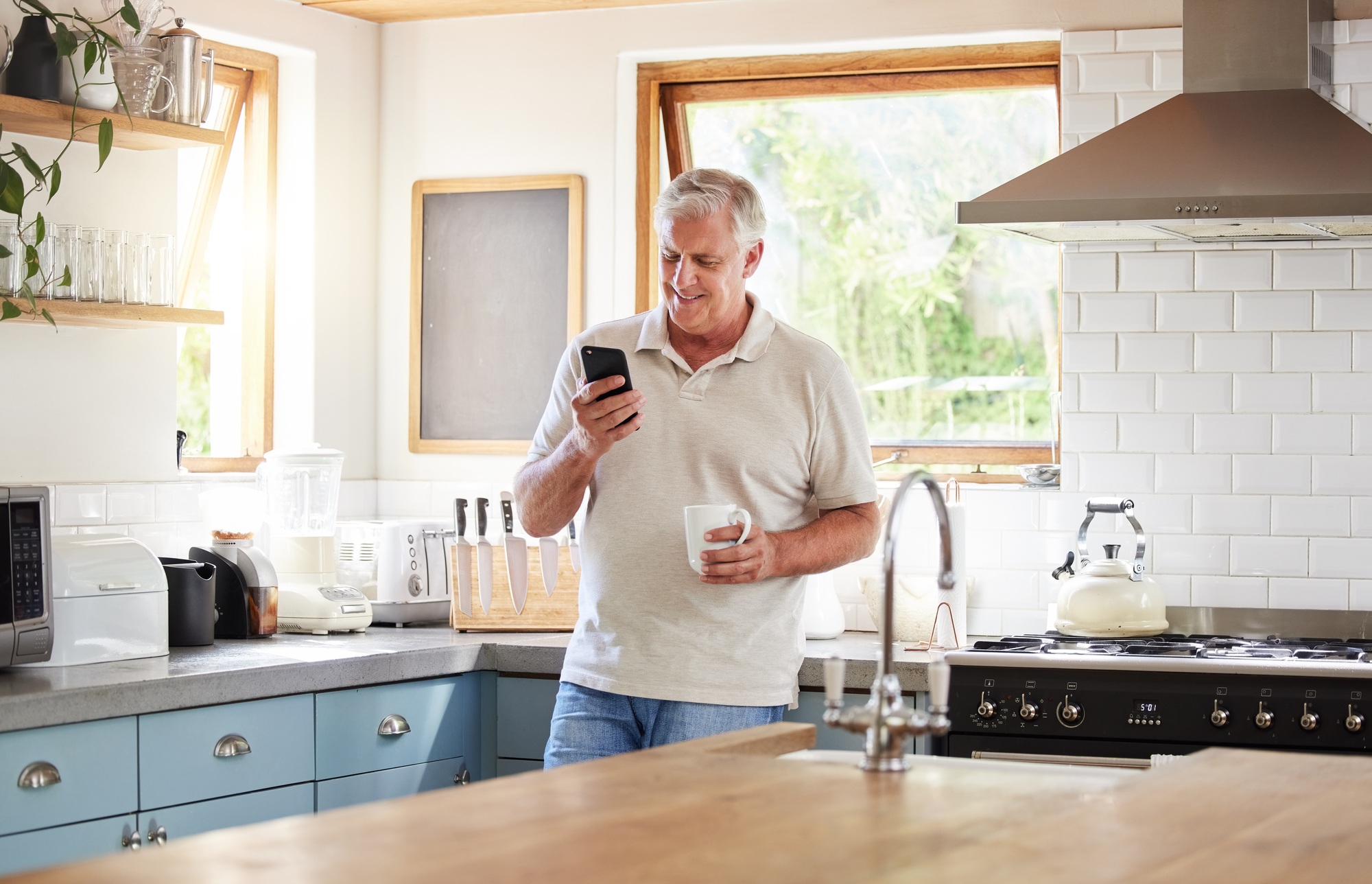 Senior man, morning coffee and phone looking happy while reading text message, online news or brows