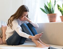 Upset woman cry read text message on smartphone suffer from breakup with boyfriend in tears on couch