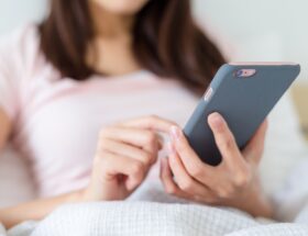 Woman use of mobile phone on bed