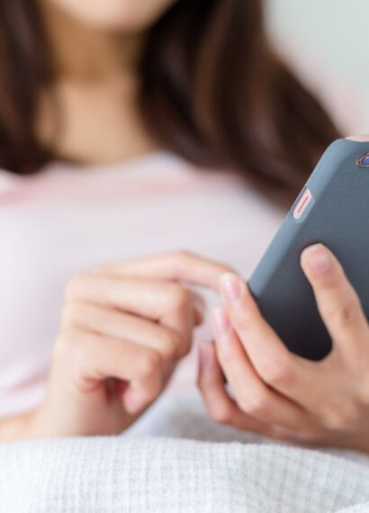 Woman use of mobile phone on bed