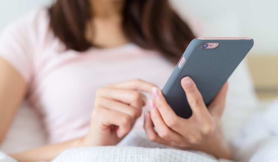 Woman use of mobile phone on bed