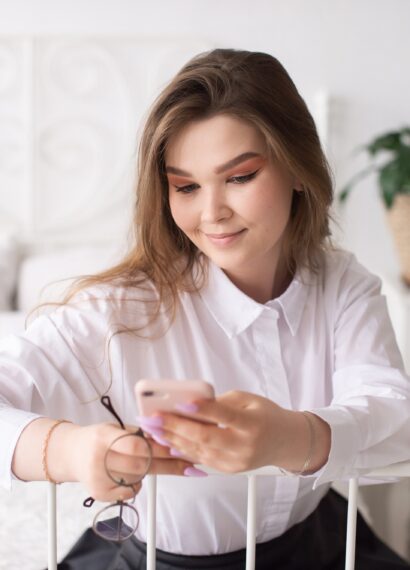 Young businesswoman reading news or sending text message