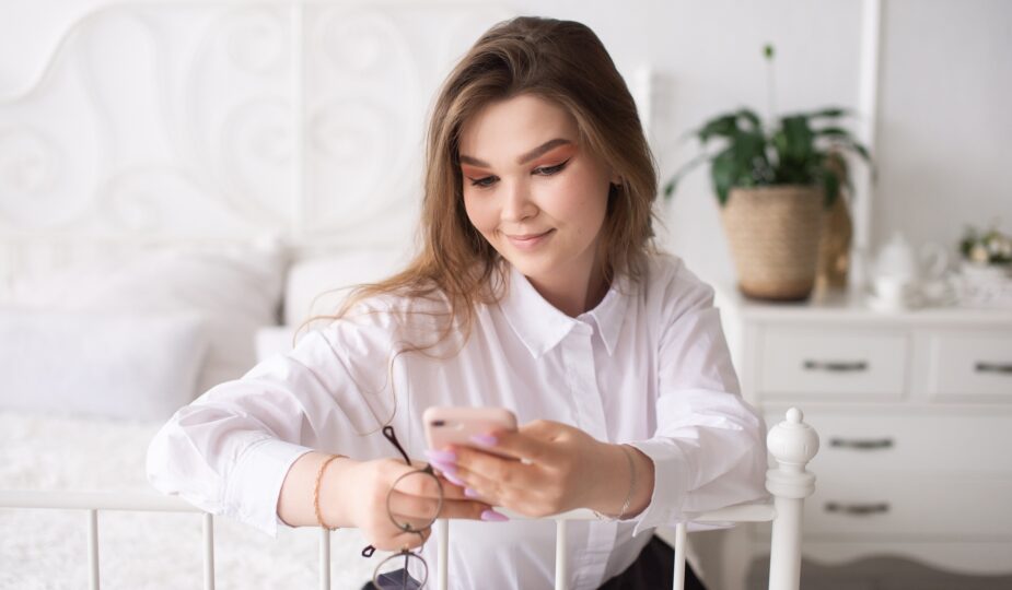 Young businesswoman reading news or sending text message