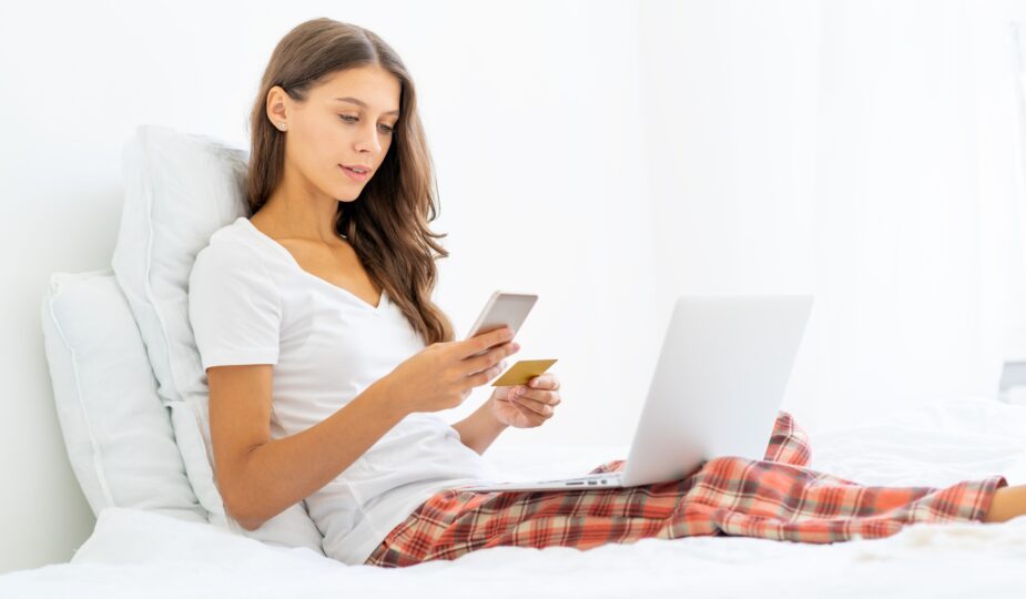 Young woman shopping online, entering code from SMS message on mobile phone, security